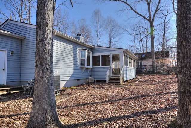 view of side of home featuring central AC and a sunroom