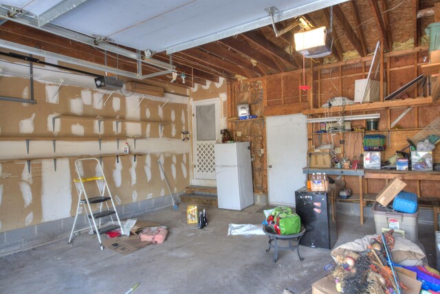 garage with a garage door opener and white fridge