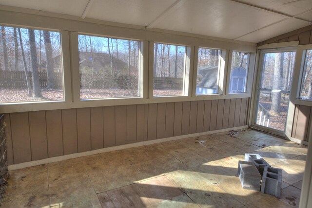 unfurnished sunroom featuring lofted ceiling and a wealth of natural light