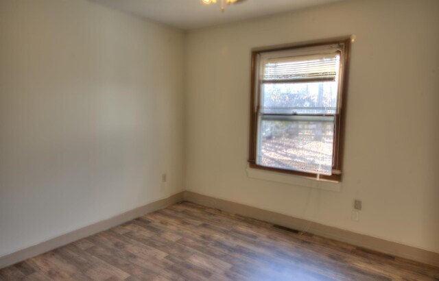 unfurnished room with dark wood-type flooring