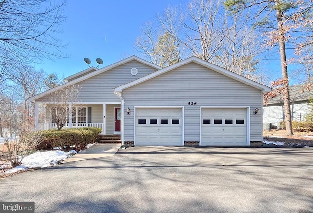 single story home with a garage, covered porch, and driveway