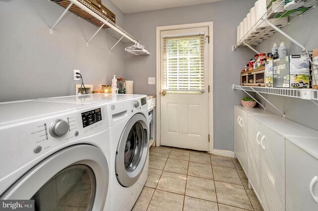 washroom featuring laundry area, washer and clothes dryer, baseboards, and light tile patterned floors