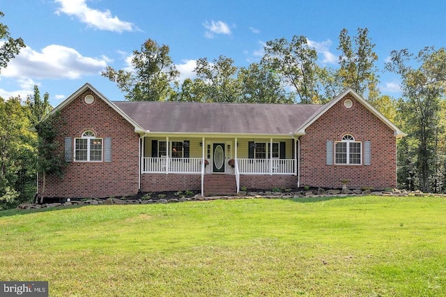 ranch-style home featuring a porch, a front yard, and brick siding