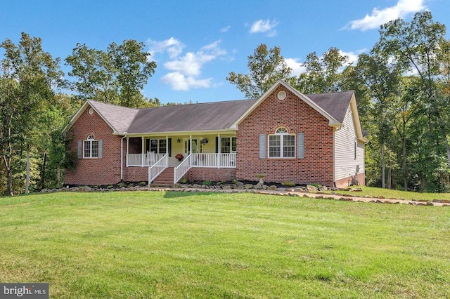 ranch-style home featuring covered porch, brick siding, and a front yard