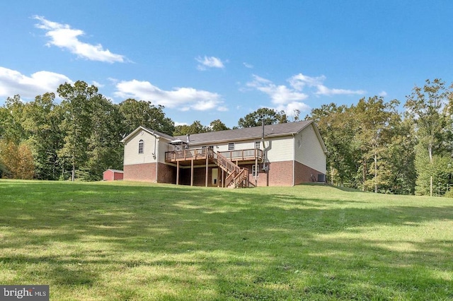 back of property with brick siding, stairway, a lawn, and a wooden deck