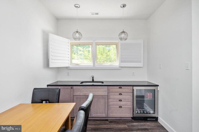 office space featuring wine cooler, sink, and dark wood-type flooring