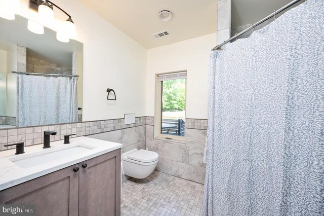 bathroom featuring tile patterned flooring, tile walls, vanity, a shower with curtain, and toilet