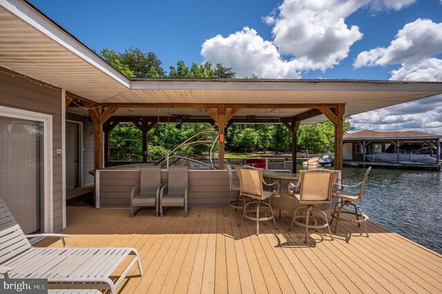 view of dock with a water view and an outdoor bar