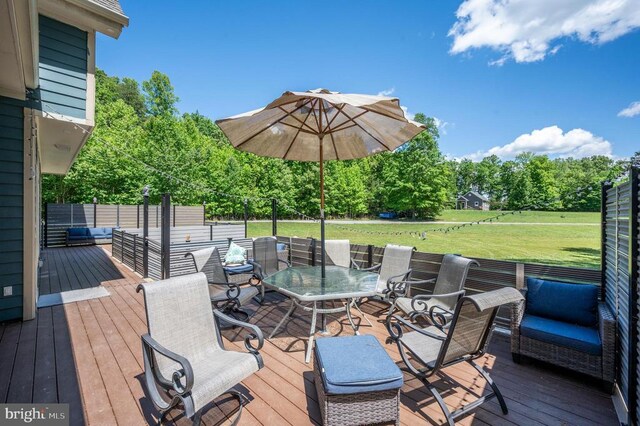 deck with an outdoor living space and a yard