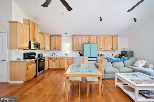 kitchen with sink, appliances with stainless steel finishes, tasteful backsplash, light brown cabinetry, and light wood-type flooring