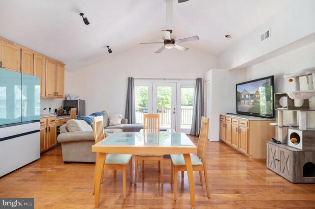 dining space featuring vaulted ceiling, ceiling fan, and light hardwood / wood-style flooring