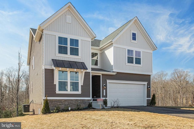 view of front of house with aphalt driveway, board and batten siding, a standing seam roof, metal roof, and a garage