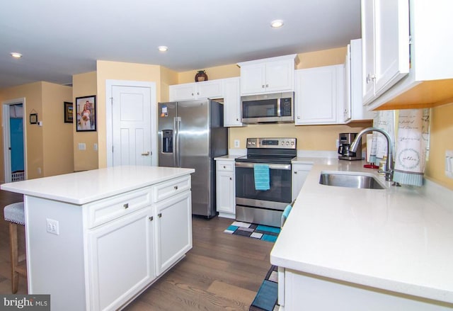 kitchen with stainless steel appliances, light countertops, a sink, and white cabinetry