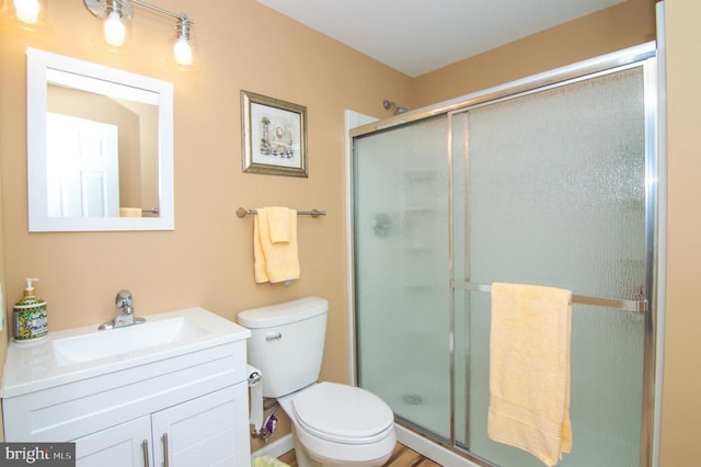 full bath featuring toilet, a shower stall, and vanity