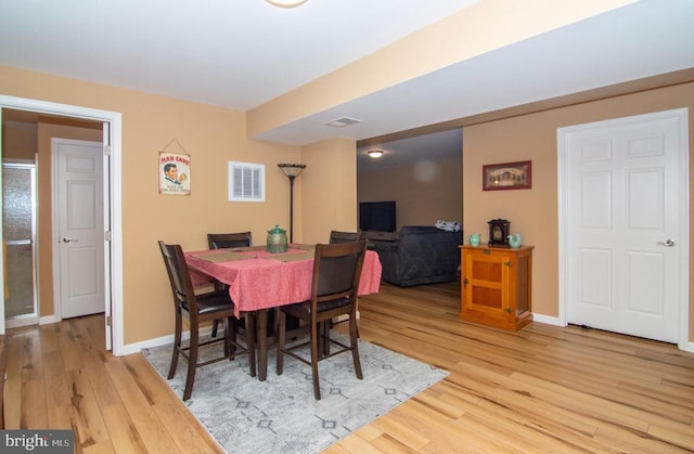 dining room featuring light wood-style floors, baseboards, and visible vents