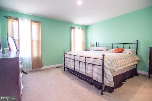 carpeted bedroom with visible vents and baseboards