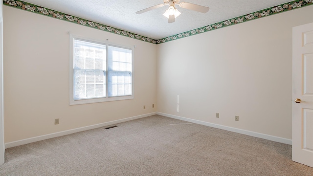 empty room featuring light carpet, baseboards, visible vents, and a textured ceiling