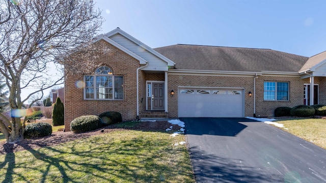 view of front of house featuring a garage, brick siding, a front lawn, and aphalt driveway