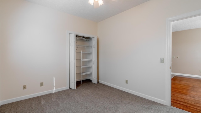 unfurnished bedroom featuring a textured ceiling, carpet floors, a closet, and baseboards