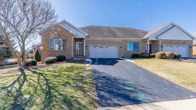 ranch-style house featuring a garage, a front yard, brick siding, and driveway