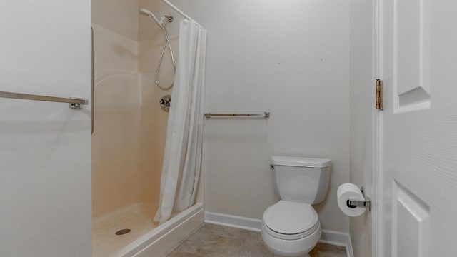 full bathroom with a stall shower, toilet, and baseboards