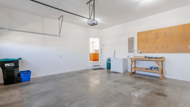 garage with a garage door opener, electric panel, baseboards, and a workshop area