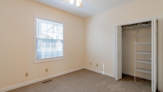 unfurnished bedroom with light carpet, visible vents, baseboards, ceiling fan, and a closet