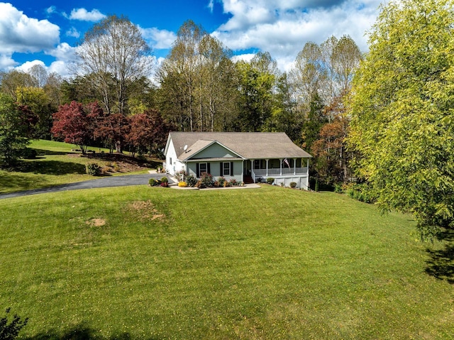 view of front of home with a sunroom and a front lawn