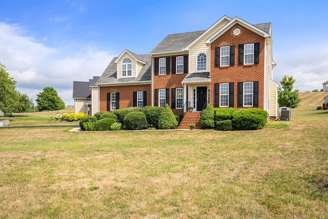 colonial-style house with central air condition unit and a front lawn