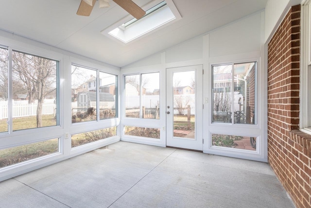 unfurnished sunroom featuring lofted ceiling with skylight and ceiling fan