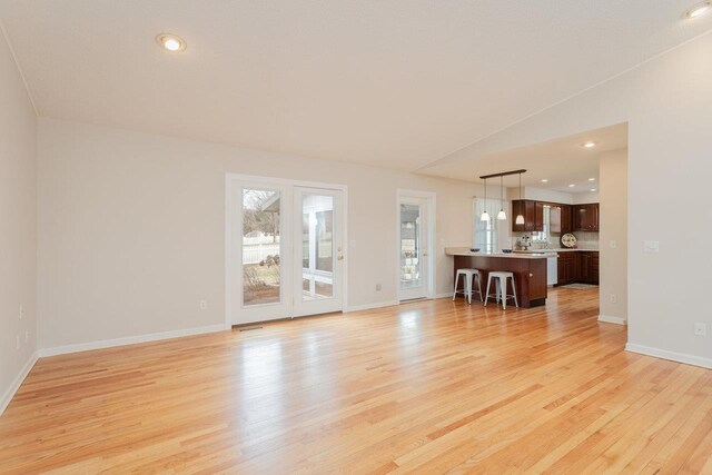 unfurnished living room with recessed lighting, light wood-style flooring, visible vents, and baseboards