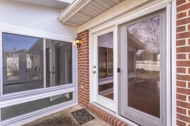 doorway to property featuring brick siding