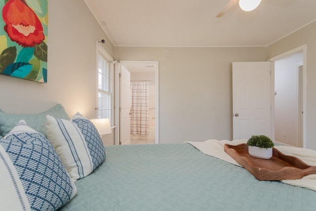 bedroom with ceiling fan, connected bathroom, and ornamental molding