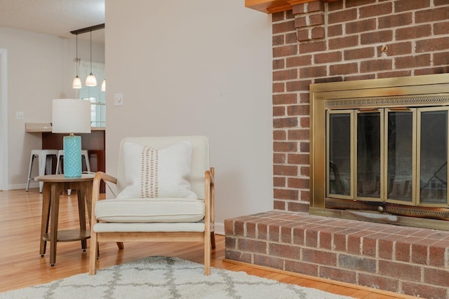 living area with baseboards and wood finished floors