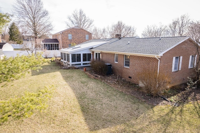 back of property featuring central air condition unit, a yard, a sunroom, crawl space, and brick siding