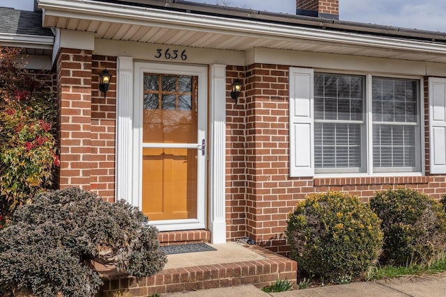 doorway to property featuring brick siding