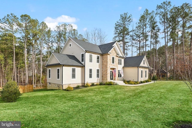 view of front of home with a front yard, fence, and roof with shingles