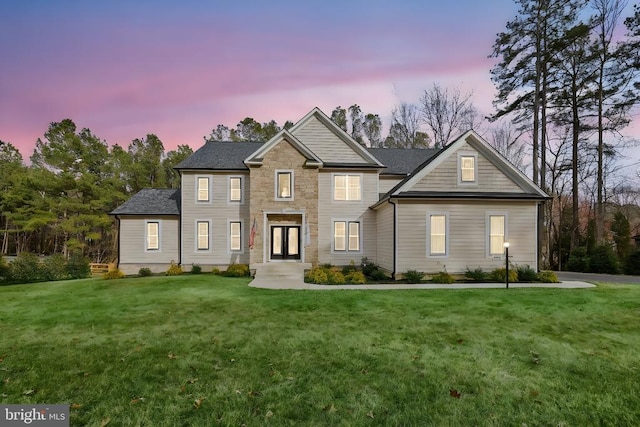 view of front of home with a yard and stone siding