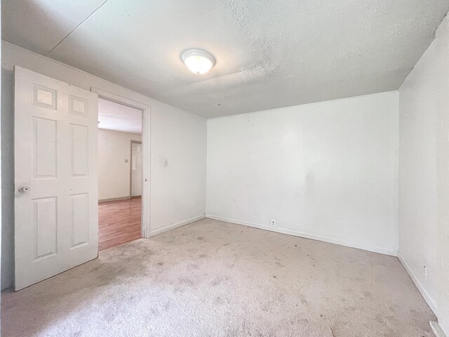 spare room with a textured ceiling and carpet flooring