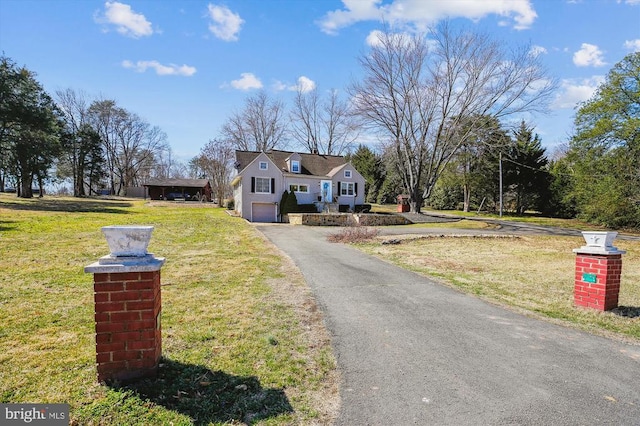 view of front of home featuring aphalt driveway, a front lawn, and an attached garage