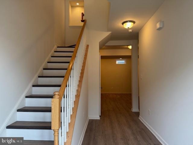 stairway with baseboards and wood finished floors