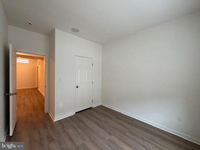 unfurnished bedroom with dark wood finished floors and baseboards