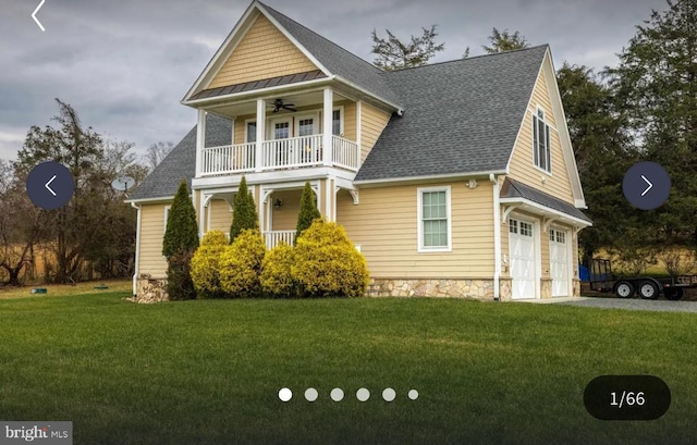 view of front of home with ceiling fan, a balcony, a garage, and a front lawn