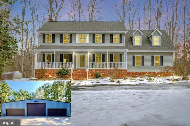 view of front facade featuring a porch, a shingled roof, a detached garage, and an outdoor structure