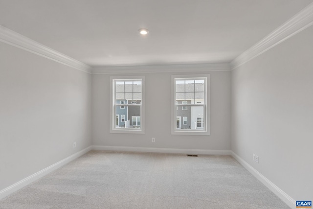 spare room with light carpet, visible vents, baseboards, and crown molding