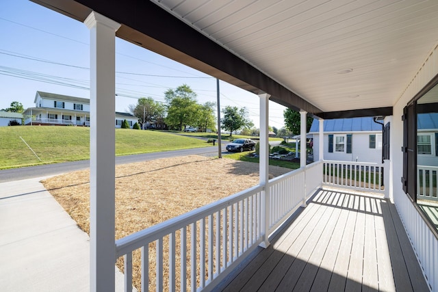 wooden terrace featuring a yard and covered porch
