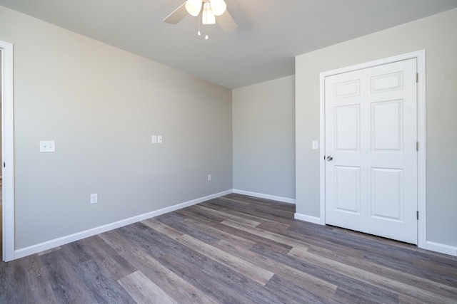 empty room featuring baseboards, a ceiling fan, and wood finished floors
