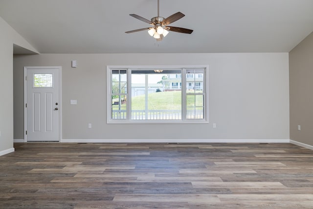 unfurnished living room with ceiling fan, vaulted ceiling, a wealth of natural light, and wood finished floors