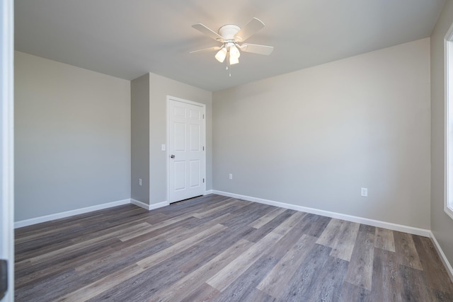 empty room with baseboards, a ceiling fan, and wood finished floors