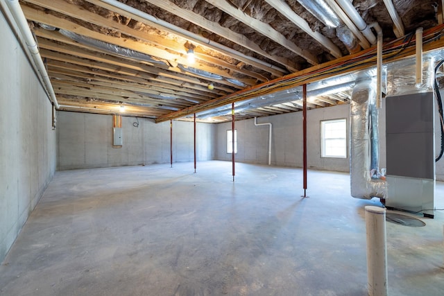 basement featuring heating unit and electric panel